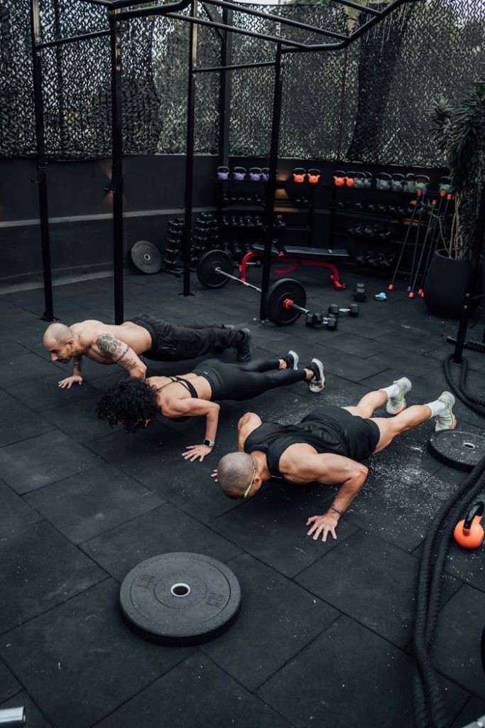 Mastering the First Impression: Your intriguing post title goes here Tres personas haciendo flexiones en un gimnasio